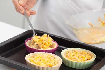 Senior woman preparing a delicious cheese and ham tartlet