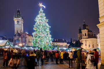People celebrating Christmas religious holiday outdoors into the downtown of Prague among the tree and lights decoration in winter season