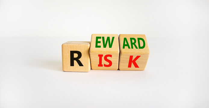 Risk or reward symbol. Turned wooden cubes and changed the word 'risk' to 'reward'. Beautiful white background. Risk or reward and business concept. Copy space.