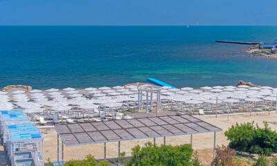Obraz premium Sea beach with sand and row of wooden umbrellas
