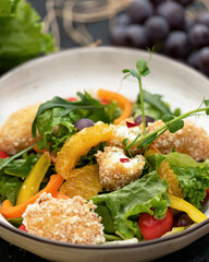 Colorful vegetable dish with microgreens, Close up . Bowl with mixed orange, nuggets, lettuce, grapes and tomatoes. Beautiful view of restaurant healthy food. Soft focus.