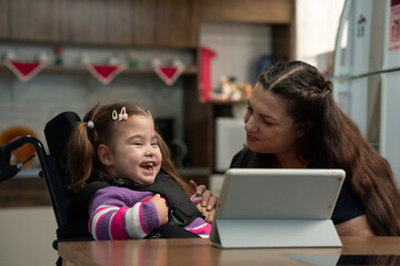 disabled baby laughing with mother at table.