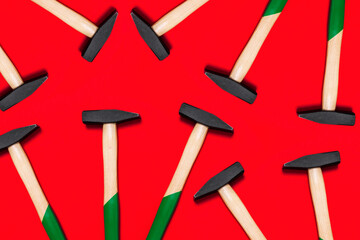 Pattern of hammers isolated on red background. Shop banner with construction tools. New Year or Christmas festive backdrop. One of the basic home use instrument for hammering nails. Building design