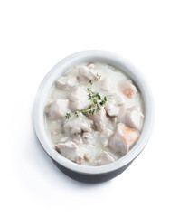 Chicken breast in creamy garlic sauce in ceramic bowl isolated on white