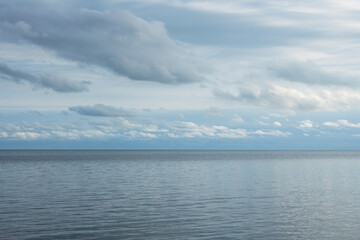 Panoramic view of blue sea and clear sky with white clouds.Nature,climate change,reflections of symmetry on water in daylight.The idea of ​​feeling calm and relaxing for the background and copy space.