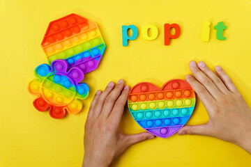 Colorful anti stress touch pop it toy. On a yellow background. Top view