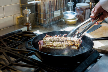Rack of lamb cooking in cast iron skillet