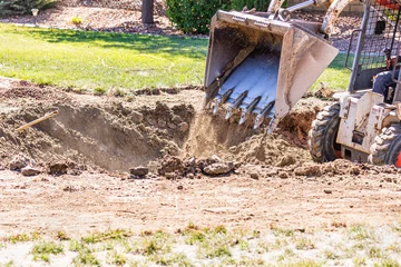 Fotobehang Small Bulldozer Digging In Yard For Pool Installation © Andy Dean