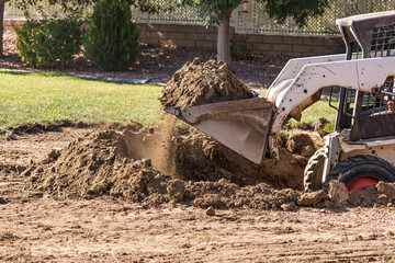 Small Bulldozer Digging In Yard For Pool Installation