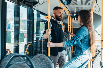 Young couple standing in a moving bus