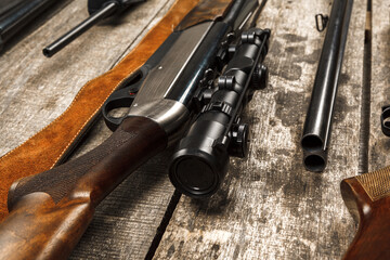 Many hunting rifles on weathered wooden surface