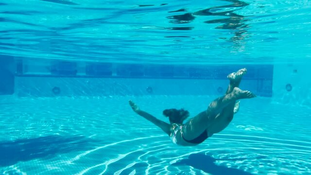 Beautiful young lady swimming underwater 