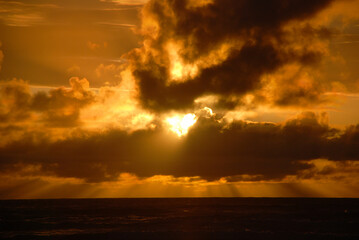 Fototapeta na wymiar Setting Sun Breaking Through Clouds
