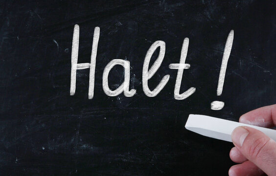 Closeup shot of a white text "Halt!" on a black surface