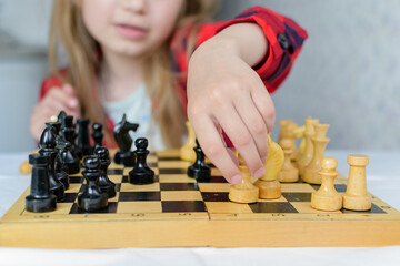 International Chess Day. A little girl learns chess pieces and learns to play chess.Table games....