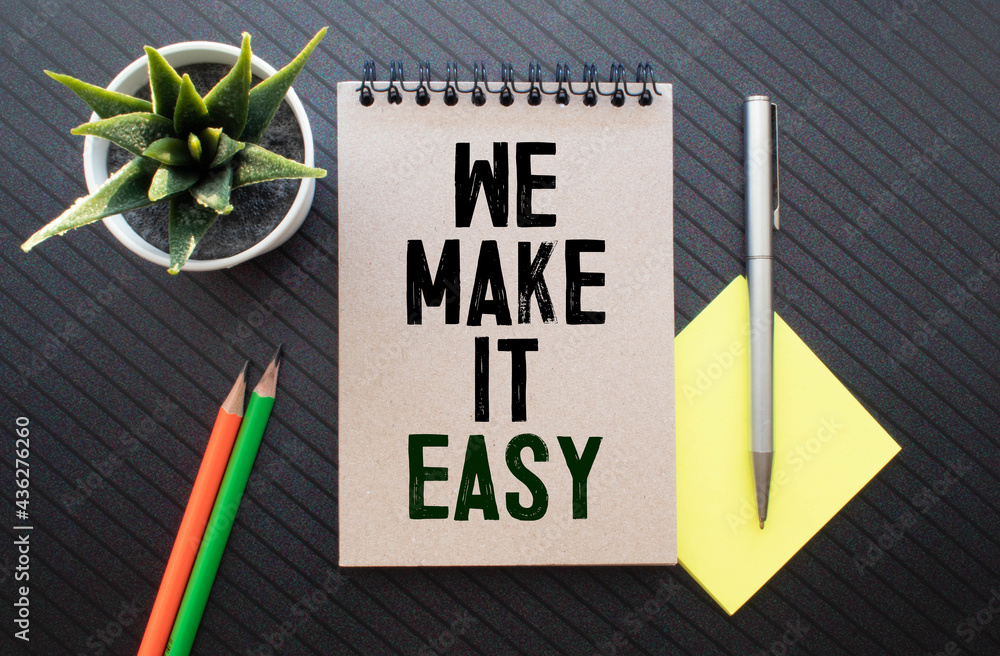 Poster we make it easy text in the notebook on a wooden table. top view - business concept.