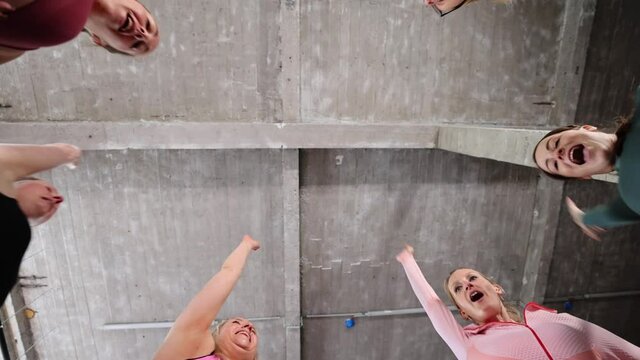 Group or team of happy young sportive women in a gym all cheering with hands up and applauding. High quality FullHD footage