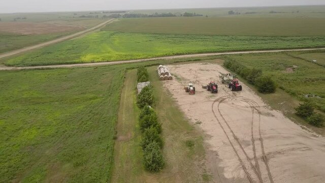 Aerial Forward Shot Of Tractors Amidst Green Landscape, Agricultural Field Against Sky - Oakley, Kansas