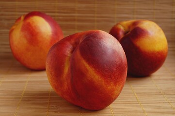 Ripe nectarines on bamboo background. Close-up