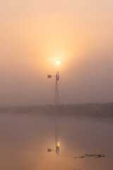Obraz premium Thick fog over the windmill during sunrise time.
