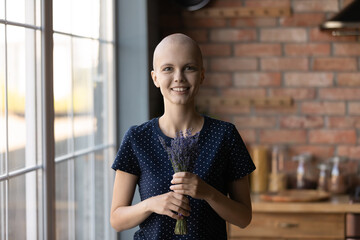Happy oncology patient beating cancer, going through recovery to remission. Young hairless woman...
