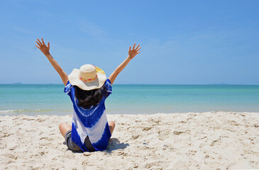 Happy woman enjoying freedom with open hands on the beach at sea