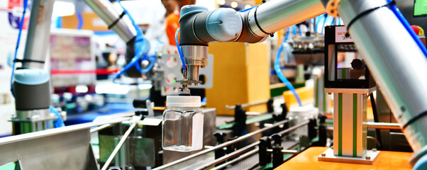 Robot arm arranged glass water bottle on Automatic industrial machinery equipment in production line factory
