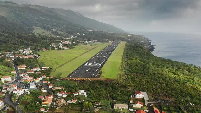 Sao Jorge island, Azores, Portugal. Panoramic view with a small airport and charming cottages. Drone footage of a coastal town on the shore of the Atlantic Ocean. High quality 4k footage