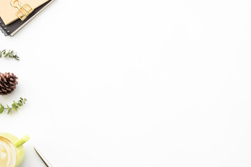 White office desk table with cup of latte coffee and office supplies. Top view with copy space, flat lay.