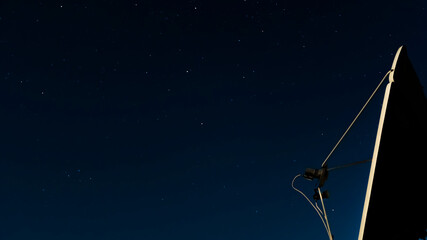 The night starry sky against of a satellite dish.Exploring the cosmos and the...