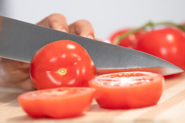 Woman cutting fresh tomato: Selective focus. Diet and healthy food concept