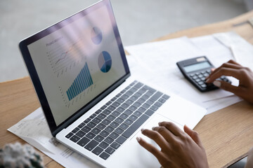 Close up young african american business woman reviewing project economic statistics, calculating...