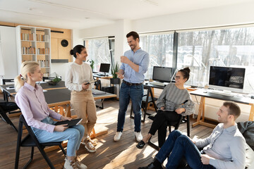 Obraz premium Happy diverse colleagues employees team having fun at meeting, sitting in circle, workers interns sharing ideas or funny news, involved in briefing, pleasant conversation, discussing project strategy