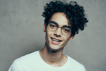 funny curly guy in a white t-shirt glasses emotions studio fashion
