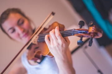 Practicing classical music and violin concept: Young girl happily plays on her violin