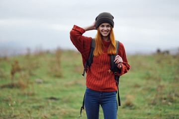 Fototapeta premium cheerful woman hiker in autumn clothes with a cutter in the mountains landscape on a trip