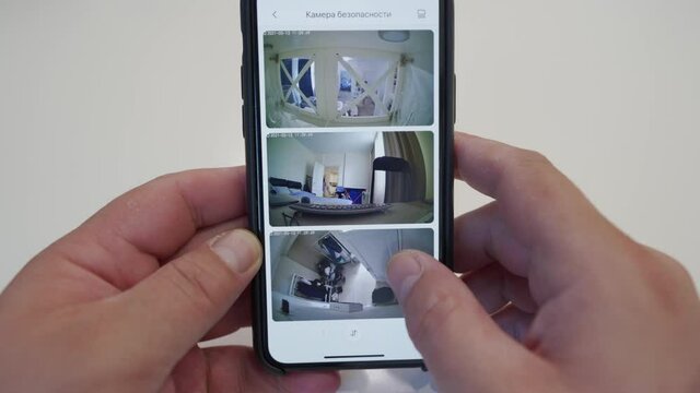 Using Wireless Ip Cctv Camera To Record Surveillance Video At Home, Man Watching Real-time Video From Security Cameras On A Mobile Phone Screen.