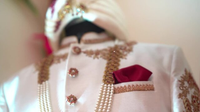 Closeup shot of groom&rsquo;s Royal wedding dress sherwani. Traditional white rich designer sherwani with turban suitable for Indian marriage.

