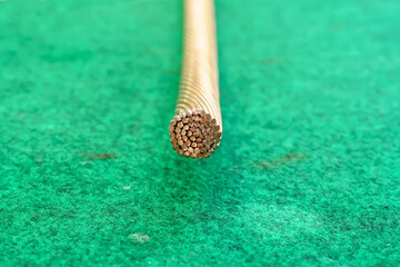 The copper strands of large wires on a artificial grass background.