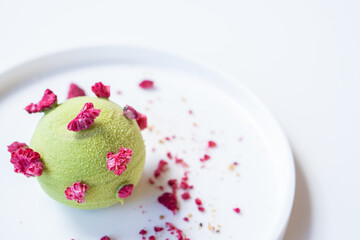 Tasty pistachio - raspberry pie on a white plate.