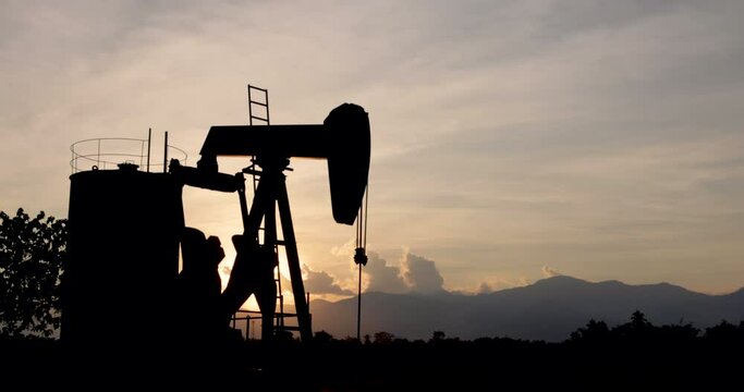Oil pump oil rig energy industrial machine for petroleum in the sunset background 4k video 