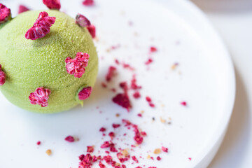 Tasty pistachio - raspberry pie on a white plate.