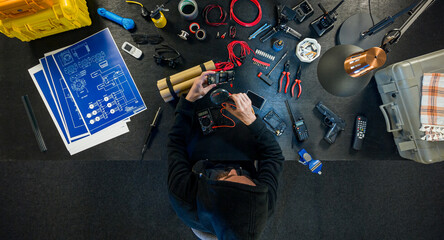 The terrorist makes a bomb in a dark basement. View of the table from above.