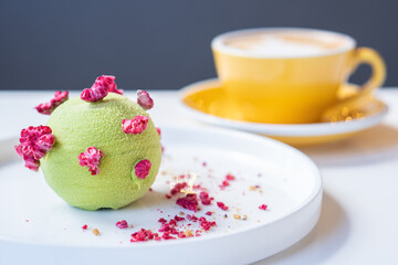 Tasty pistachio - raspberry pie on a white plate.