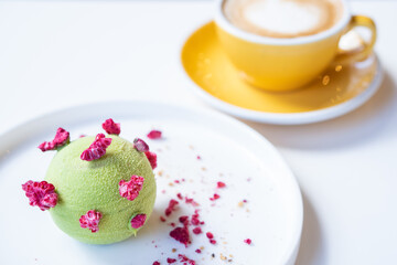 Tasty pistachio - raspberry pie on a white plate.