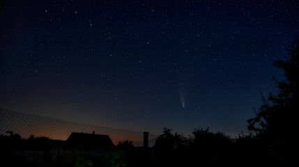 Obraz na płótnie Canvas Beautiful view of the starry sky and comet C / 2020 F3 (NEOWISE) with a light tail. a fascinating view from the window of your house outside the city.