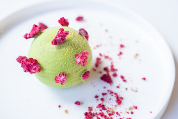 Tasty pistachio - raspberry pie on a white plate.