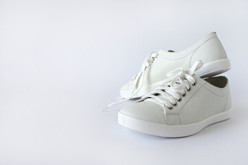 White summer women's sports shoes, stylish leather sneakers isolated on a white background. Advertising fashion shoes. Copy space
