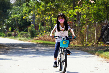 Fototapeta premium Asian child bike outdoor with mask. New normal collections