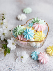 Fototapeta na wymiar Small colorful meringues in the heart shaped bowl